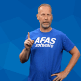 a man wearing a blue afas software t-shirt points at something