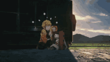 a couple of anime characters sitting next to each other in a field