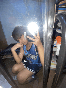 a person taking a selfie in front of a mirror wearing a jersey that says oklahoma city thunder