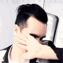 a close up of a man covering his face with his hand with the words daltonsmiles in the corner