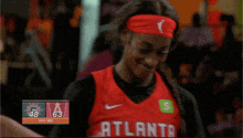 a female basketball player wearing a red jersey that says atlanta on it