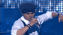 a man singing into a microphone in front of a screen that says denmark