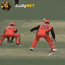 a cricket player is jumping in the air with a gullybet logo behind him