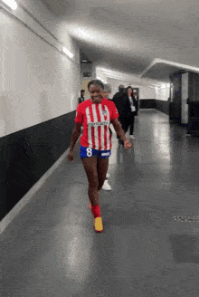 a woman wearing a red and white striped jersey with the number 8 on it