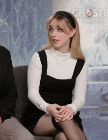 a woman sits in front of a ghostbusters poster