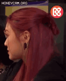 a close up of a woman with red hair and earrings .