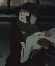 a woman is holding a baby in her arms in a dark room