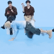 a group of young men are playing a game on a blue surface .