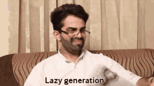a man with glasses and a beard is sitting on a couch and says lazy generation .