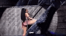 a woman is sitting on a ladder in front of a large screen .