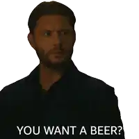 a man with a beard is holding a bottle of beer and asking if he wants a beer