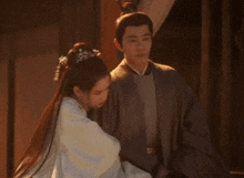 a man and a woman standing next to each other in a dark room