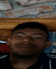 a man laying on a bed with a brick wall in the background