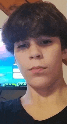 a young boy is taking a selfie in front of a tv .