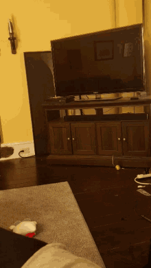 a living room with a flat screen tv on a wooden stand
