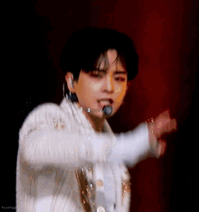 a close up of a person wearing a white jacket and a microphone .