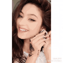 a woman with a tattoo on her hand is smiling and wearing rings