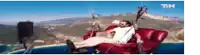 a man is laying on a red couch with a parachute attached to it .