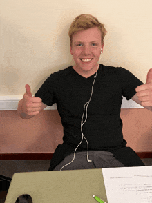 a young man giving a thumbs up while wearing earbuds
