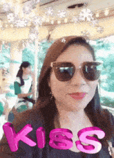 a woman wearing sunglasses has the word kiss written in pink