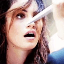 a close up of a woman 's face with her mouth open