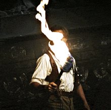 a man holding a torch with a flame coming out of his mouth
