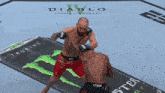 two men are fighting in a ring with a monster energy can in the background