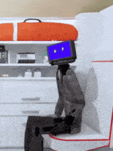 a robot with a blue screen on its head is sitting on a chair