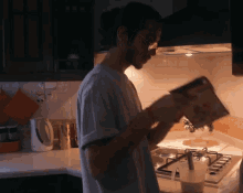 a man is pouring cereal into a measuring cup in a kitchen