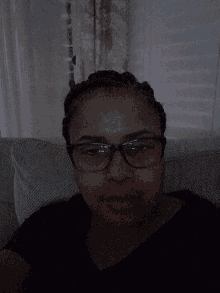 a woman wearing glasses and a black shirt is laying down