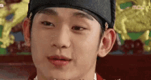 a close up of a man 's face wearing a hat and making a funny face .