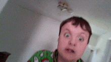 a young boy in a green sweater looks surprised and shocked
