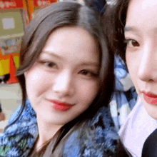 two girls are posing for a picture together and smiling at the camera .