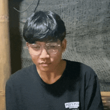 a boy wearing glasses and a shirt that says pete 's pizza