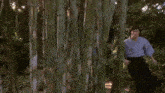 a man in a kimono and a man in a suit are walking through a bamboo forest .