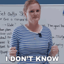 a woman standing in front of a white board with the words " i don 't know "