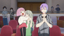 a couple of anime characters standing next to each other in a theatre .