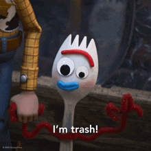 a toy story character says i 'm trash in front of a toy fork