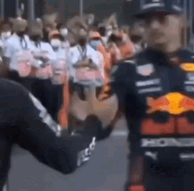 a man is shaking hands with another man in front of a crowd .
