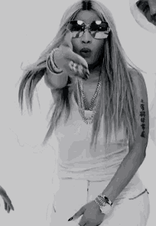 a black and white photo of a woman wearing sunglasses and a necklace