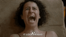 a woman is laying on her stomach with her mouth open and screaming .