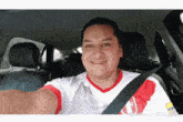 a man in a car wearing a red and white shirt that says persija