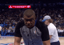 a basketball referee stands on the court in front of a sign that says ' official healthcare partners '