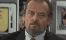 a man with a beard and a suit is making a funny face .
