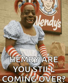 a wendy 's sign is behind a woman dressed in a wendy 's costume