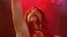 a man with long hair and a beard is dancing on stage