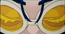 a close up of a pair of glasses with a yellow lens