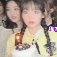 a girl in a yellow jacket is holding a white container with a blueberry on it .