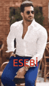 a man in a white shirt and blue pants is sitting on a chair with the word esebi written on the bottom