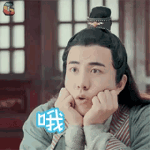 a man in a costume is making a funny face with his hands on his face .
